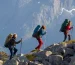 Backpacking hikers wearing Deuter Aircontact bags, while walking along a mountain trail in Senja, Norway.